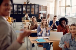 students at desks clapping